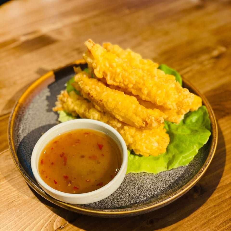 Golden fried shrimp tempura on lettuce with a side of sweet chili dipping sauce.